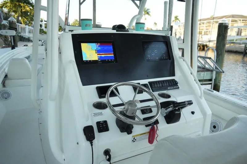 Slide: The Image of 2018 Regulator 28 boat dashboard with navigation screens and steering wheel. - 16
