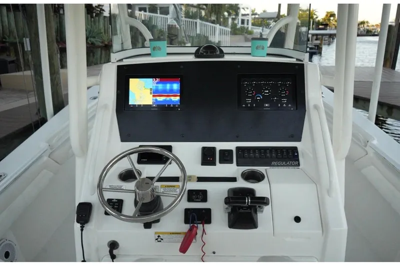 Slide: The Image of 2018 Regulator 28 boat dashboard with navigation screens and steering wheel. - 17