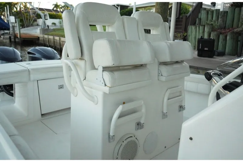 Slide: The Image of 2018 Regulator 28 boat with white cushioned seating and helm station. - 19