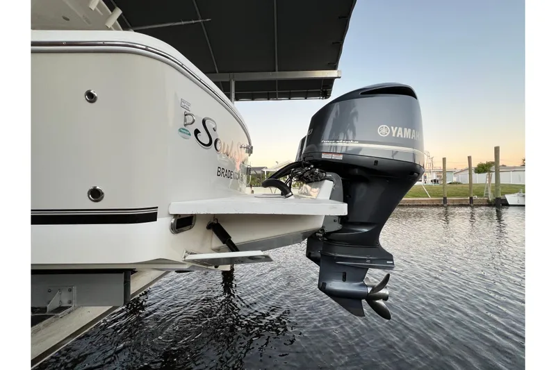 Slide: The Image of 2018 Regulator 28 boat with Yamaha outboard motor on calm water. - 2
