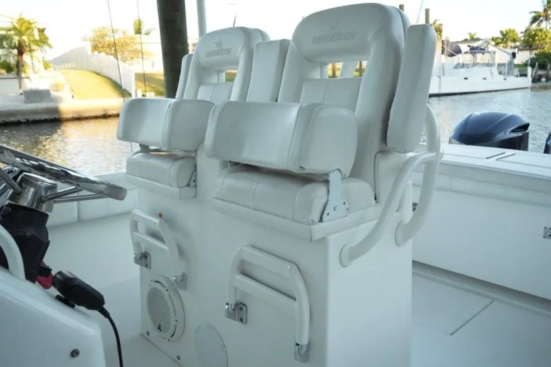 Slide: The Image of 2018 Regulator 28 boat interior with dual white captain's chairs and steering wheel. - 20