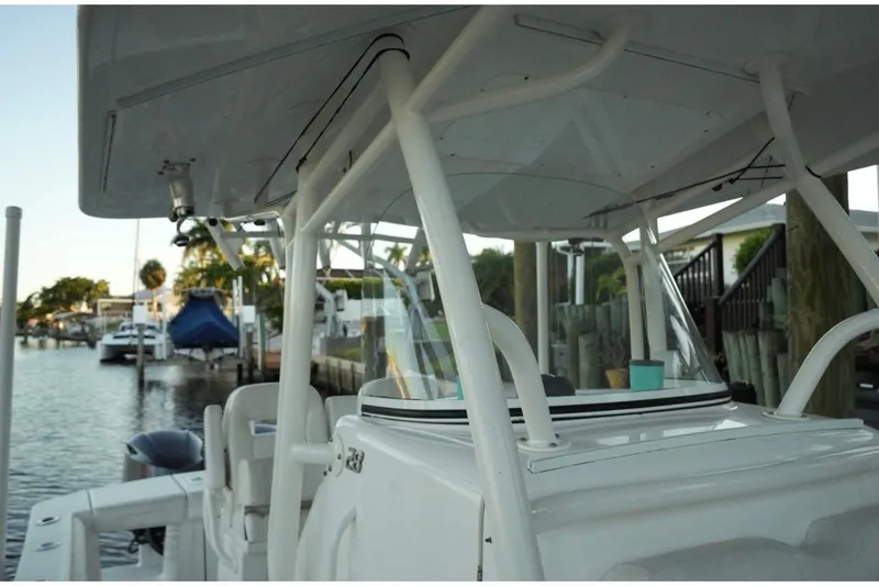 Slide: The Image of 2018 Regulator 28 boat docked by waterfront homes, showcasing sleek design and sturdy structure. - 23