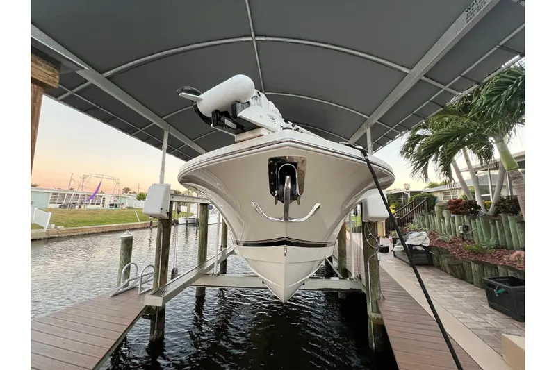 Slide: The Image of 2018 Regulator 28 boat on lift under canopy, docked by waterfront. - 31