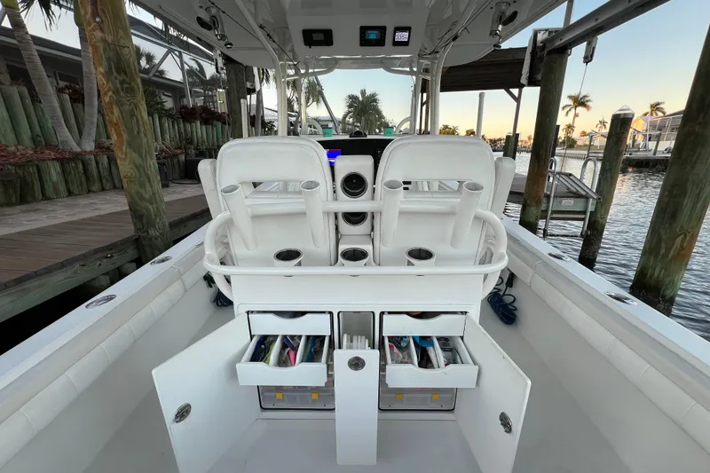 Slide: The Image of 2018 Regulator 28 boat interior with storage compartments open at a marina. - 8