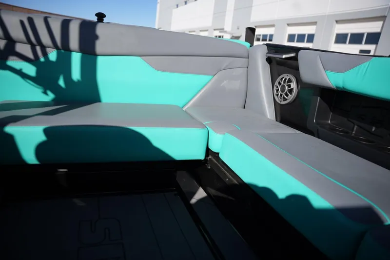 Slide: The Image of 2023 Axis A20 boat interior with teal and gray seating, featuring a speaker. - 14