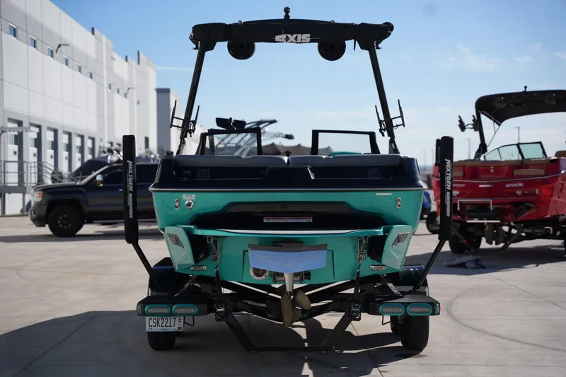 Slide: The Image of 2023 Axis A20 boat on trailer, rear view, in a marina setting. - 3