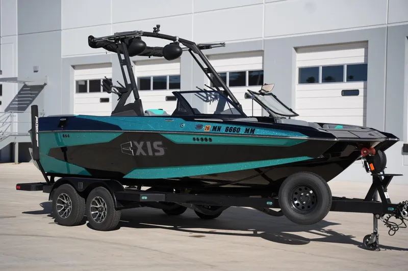 Slide: The Image of 2023 Axis A20 boat on trailer, parked outside a modern building. - 6