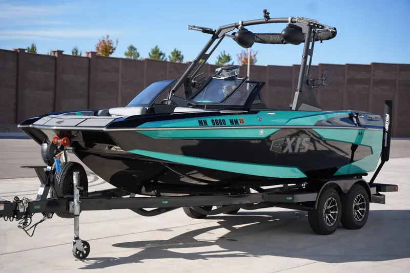 Slide: The Image of 2023 Axis A20 boat on trailer, sleek black and teal design, parked outdoors. - 8