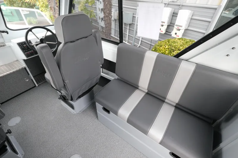 Slide: The Image of Interior of 2026 Hewescraft 210 Sea Runner ET Hardtop with gray seating and steering wheel. - 12