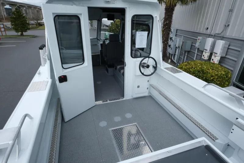 Slide: The Image of 2026 Hewescraft 210 Sea Runner ET Hardtop boat interior with open cabin door. - 7
