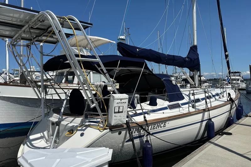 The Image of Sailboat Bavaria 44, 2003 model, docked at marina with blue covers and solar panels. - 0
