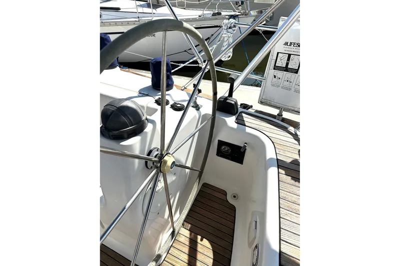Slide: The Image of Steering wheel of a 2003 Bavaria 44 yacht, featuring a sleek design and wooden deck. - 11