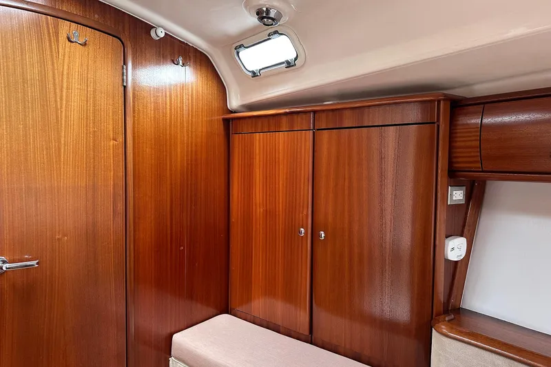 Slide: The Image of Interior of a 2003 Bavaria 44 yacht with polished wooden cabinetry and seating. - 16