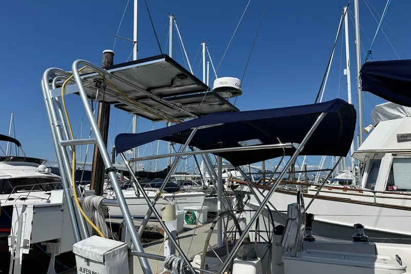 Slide: The Image of Sailboat Bavaria 44 (2003) docked at marina with blue canopy and radar equipment. - 2