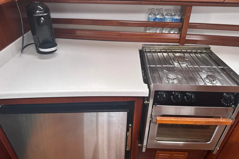 Slide: The Image of Compact kitchen in a 2003 Bavaria 44 yacht with stove, fridge, and coffee maker. - 23
