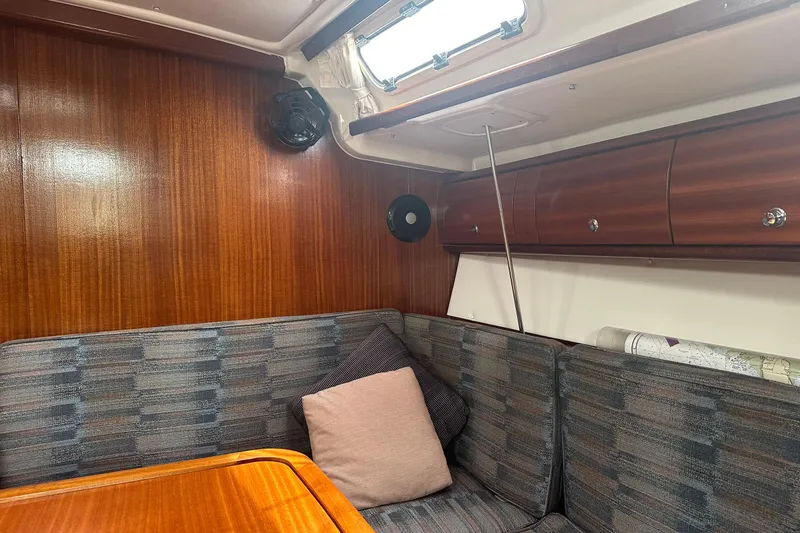 Slide: The Image of Cozy interior of 2003 Bavaria 44 yacht with wood paneling and cushioned seating. - 26