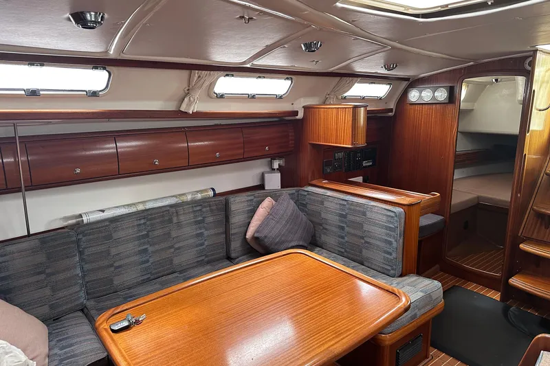 Slide: The Image of Interior of a 2003 Bavaria 44 yacht with wooden furnishings and cozy seating area. - 27