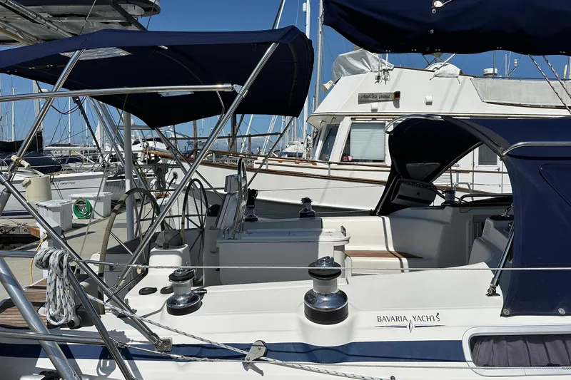Slide: The Image of 2003 Bavaria 44 yacht docked at marina, featuring blue canopy and sleek design. - 3