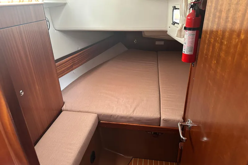 Slide: The Image of Cozy cabin interior of 2003 Bavaria 44 sailboat with wooden finish and fire extinguisher. - 31