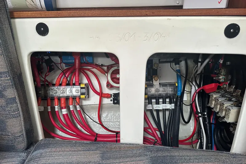 Slide: The Image of Electrical wiring system inside a 2003 Bavaria 44 yacht, featuring organized cables and connectors. - 36