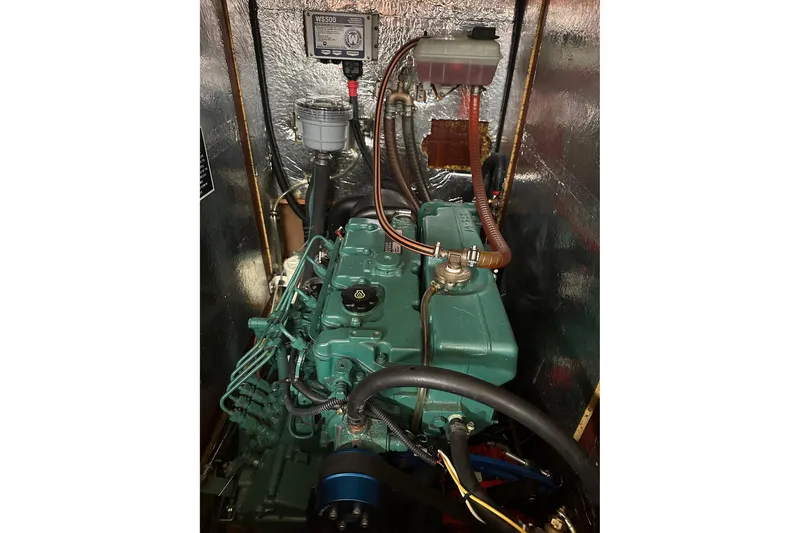 Slide: The Image of Engine compartment of a 2003 Bavaria 44 sailboat, showcasing mechanical components and wiring. - 37