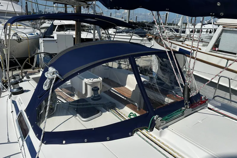 Slide: The Image of Sailboat Bavaria 44 (2003) with blue canopy docked at marina. - 9