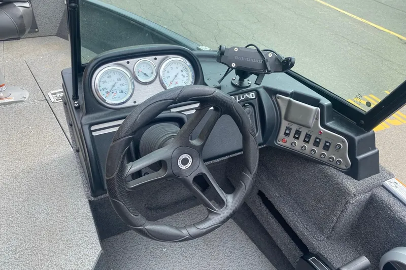Slide: The Image of 2022 Lund 1675 Adventure Sport boat dashboard with steering wheel and control panel. - 10