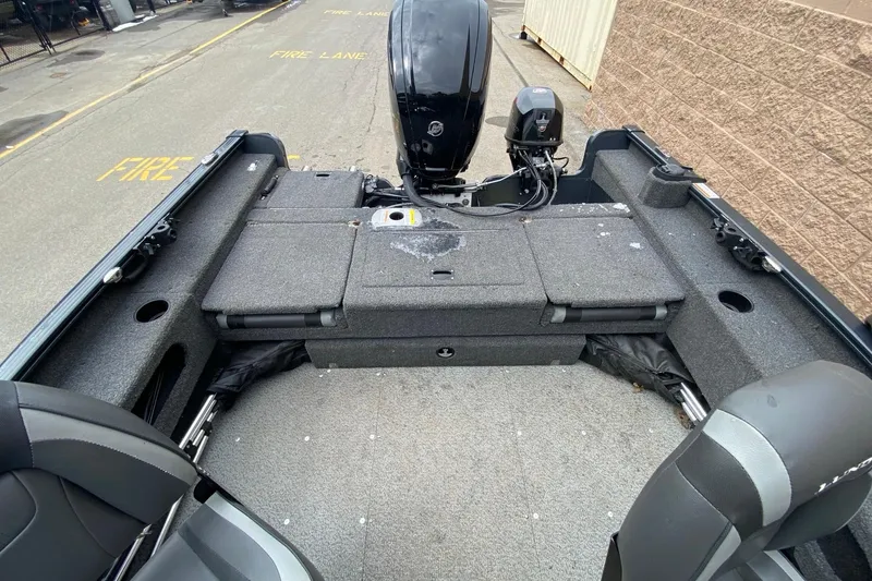 Slide: The Image of 2022 Lund 1675 Adventure Sport boat interior with motor, gray seating, and storage compartments. - 13