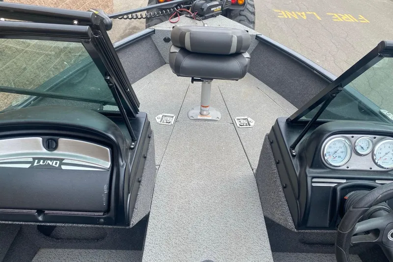 Slide: The Image of 2022 Lund 1675 Adventure Sport boat interior with seating and dashboard controls. - 17