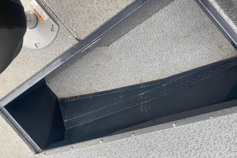 Slide: The Image of Interior view of 2022 Lund 1675 Adventure Sport boat, showing storage compartment and flooring. - 18