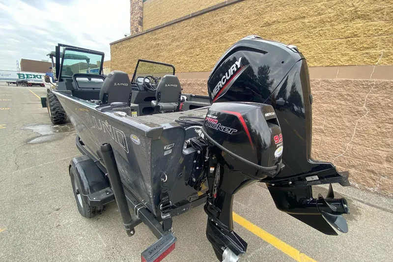 Slide: The Image of 2022 Lund 1675 Adventure Sport boat with Mercury outboard motor, parked outdoors. - 2