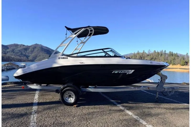 The Image of 2025 Yamaha Boats AR190 on trailer by scenic lake and mountains. - 1