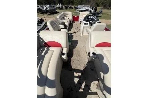 Slide: The Image of 2018 Landau Island Breeze 232 Sport Cruise pontoon boat interior with beige and red seating. - 2