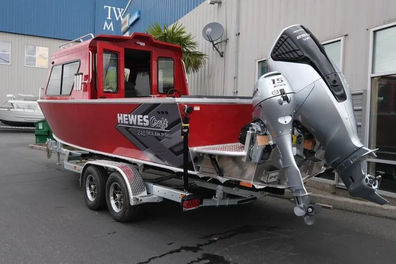 Slide: The Image of Red 2026 Hewescraft 240 Ocean Pro ET Hardtop boat on trailer, parked outside a building. - 4