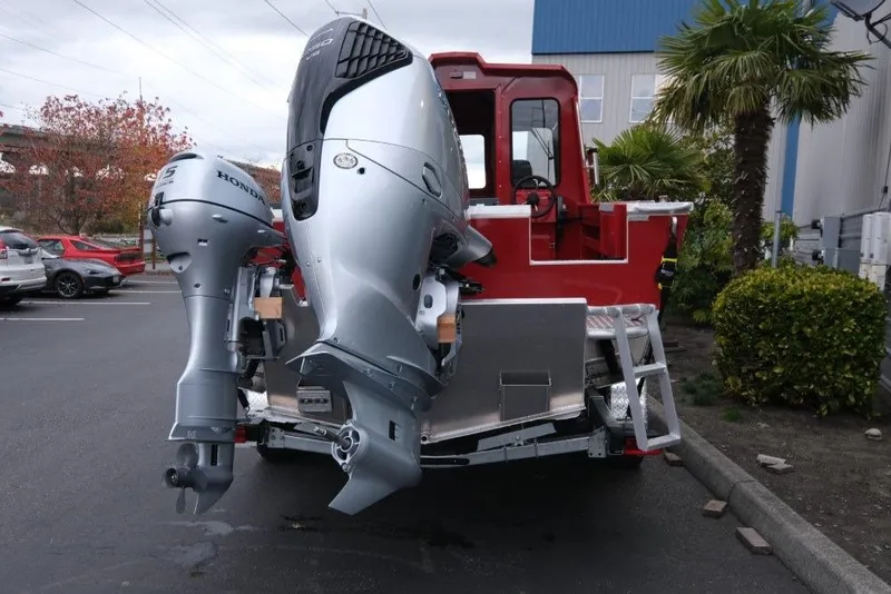 Slide: The Image of 2026 Hewescraft 240 Ocean Pro ET Hardtop with dual outboard motors in a parking lot. - 6