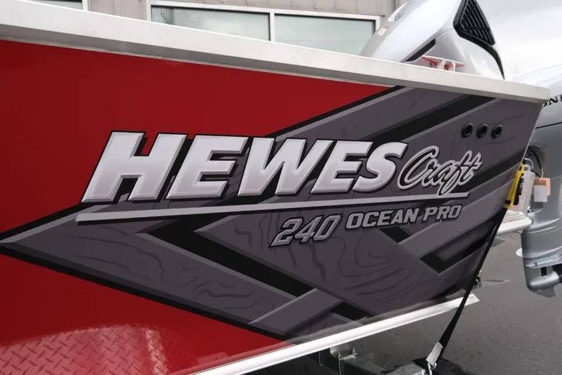 Slide: The Image of 2026 Hewescraft 240 Ocean Pro ET Hardtop boat with bold branding on red exterior. - 7