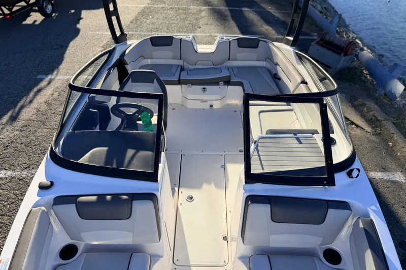 Slide: The Image of 2025 Yamaha Boats AR190 interior with open cockpit and seating, docked by the water. - 25