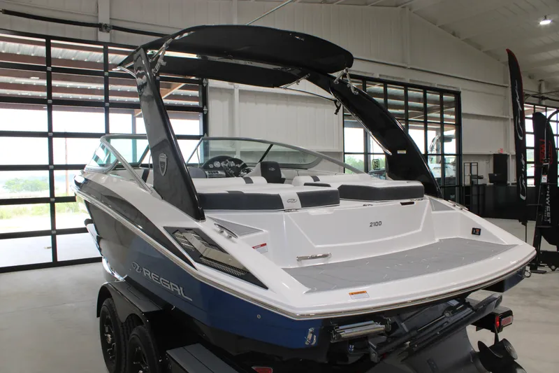 Slide: The Image of 2017 Regal 2100 Bowrider boat in showroom, featuring sleek design and modern amenities. - 16