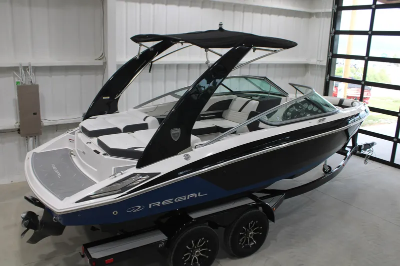 Slide: The Image of 2017 Regal 2100 Bowrider boat in showroom, featuring sleek design and modern amenities. - 17