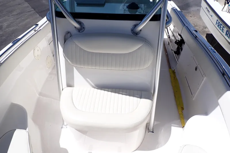 Slide: The Image of 2006 Robalo R220 Center Console boat seating area with white cushioned seats. - 10