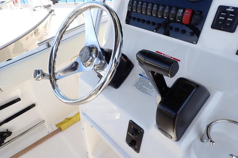 Slide: The Image of Steering wheel and controls of a 2006 Robalo R220 Center Console boat. - 17