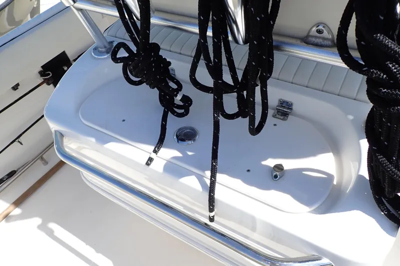 Slide: The Image of 2006 Robalo R220 Center Console boat with black ropes and storage compartment. - 22