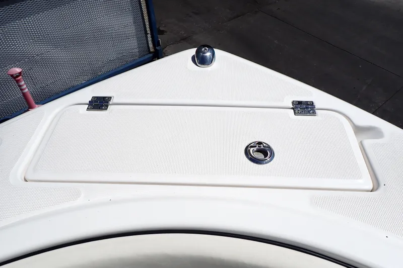 Slide: The Image of 2006 Robalo R220 Center Console boat deck with storage hatch and metal fittings. - 26