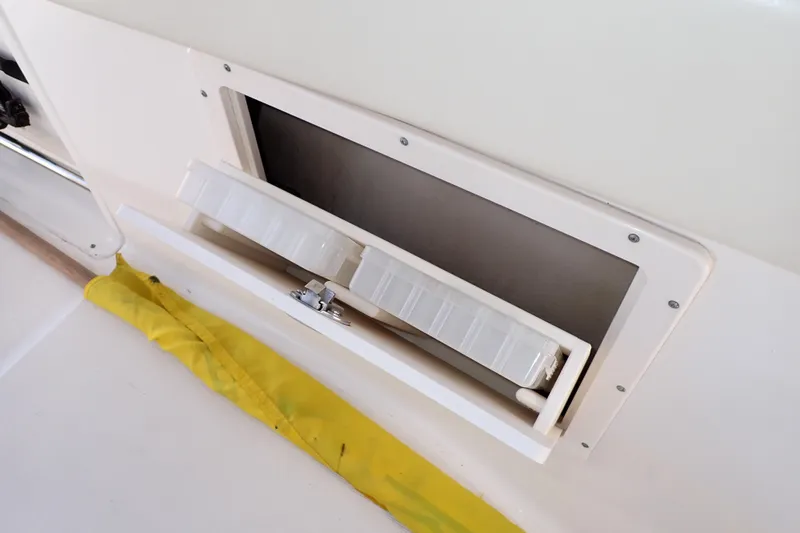 Slide: The Image of Storage compartment on a 2006 Robalo R220 Center Console boat with yellow cover. - 38
