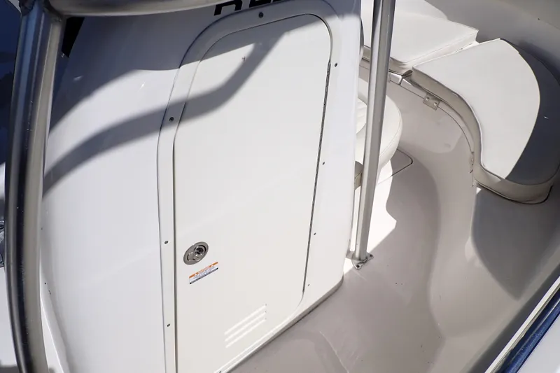 Slide: The Image of 2006 Robalo R220 Center Console interior with white seating and storage compartment. - 39