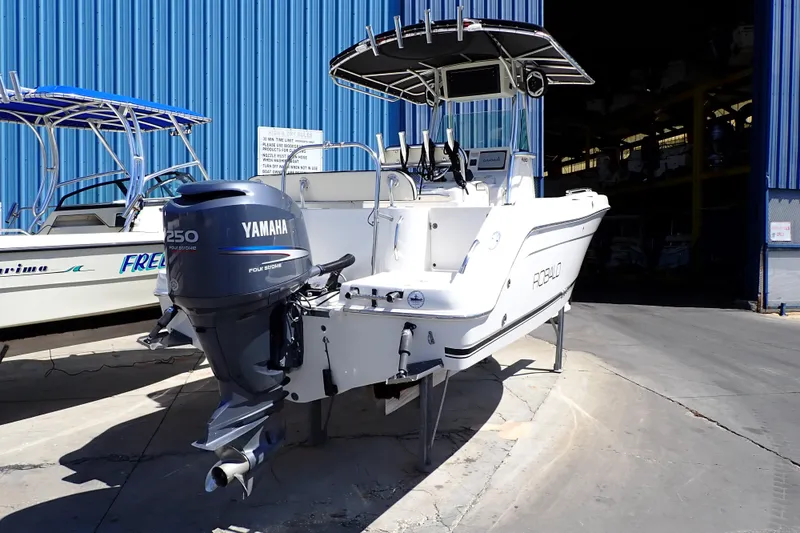 Slide: The Image of 2006 Robalo R220 Center Console boat with Yamaha 250 engine, docked near blue warehouse. - 4