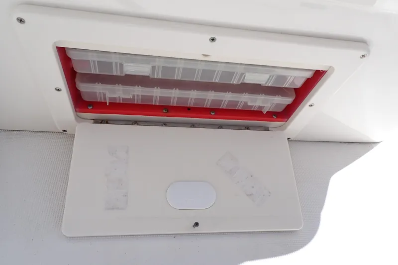 Slide: The Image of Storage compartment on a 2006 Robalo R220 Center Console boat, featuring organized tackle boxes. - 44