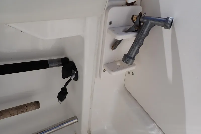 Slide: The Image of 2006 Robalo R220 Center Console boat interior with fishing rod holder and hose attachment. - 45