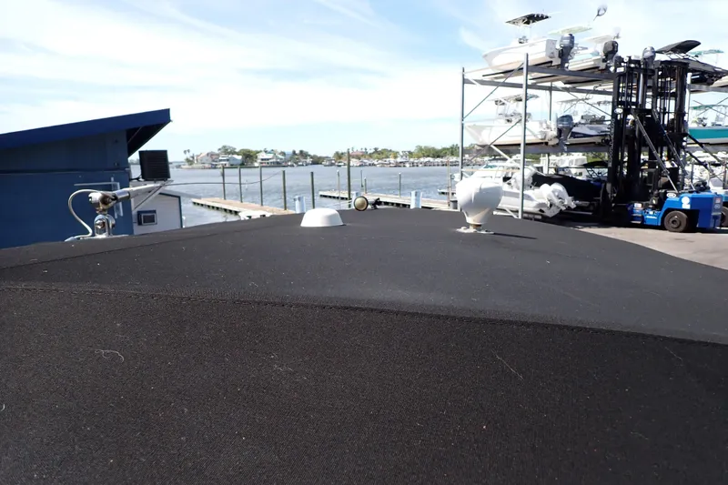 Slide: The Image of 2006 Robalo R220 Center Console boat docked near marina with stacked boats. - 53