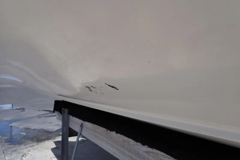 Slide: The Image of 2006 Robalo R220 Center Console boat hull with visible scratches. - 73